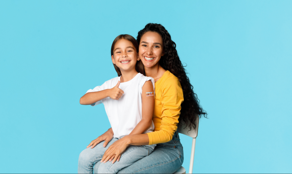 Women with child on her lap with colorful Band-Aid on her arm