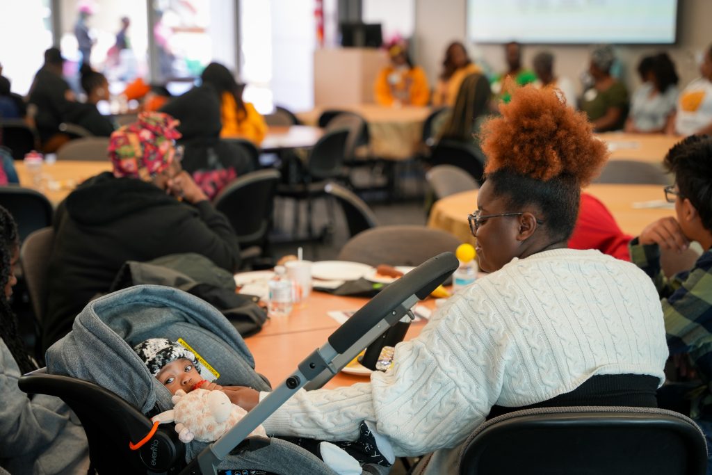 A mom and baby at the event sitting at a table.