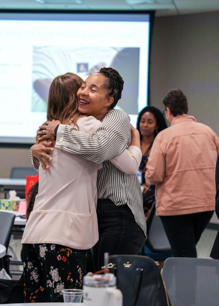 Two women hugging at the 2024 Perinatal Equity Initiative (PEI) Provider and Community Summit