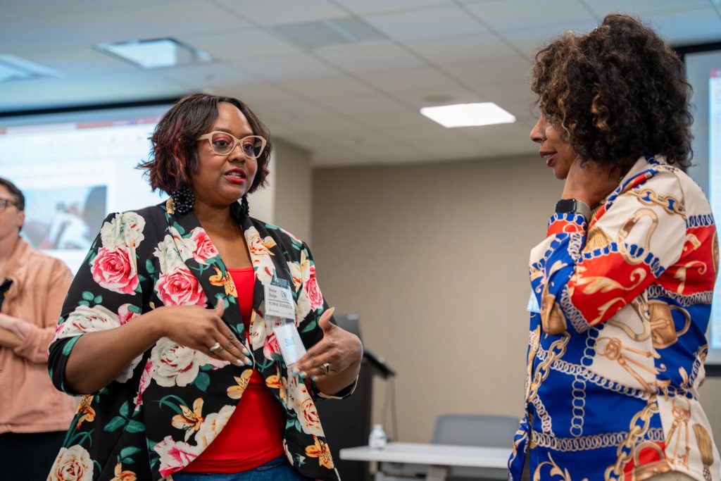 Two women talking at 2024 Perinatal Equity Initiative (PEI) Provider and Community Summit