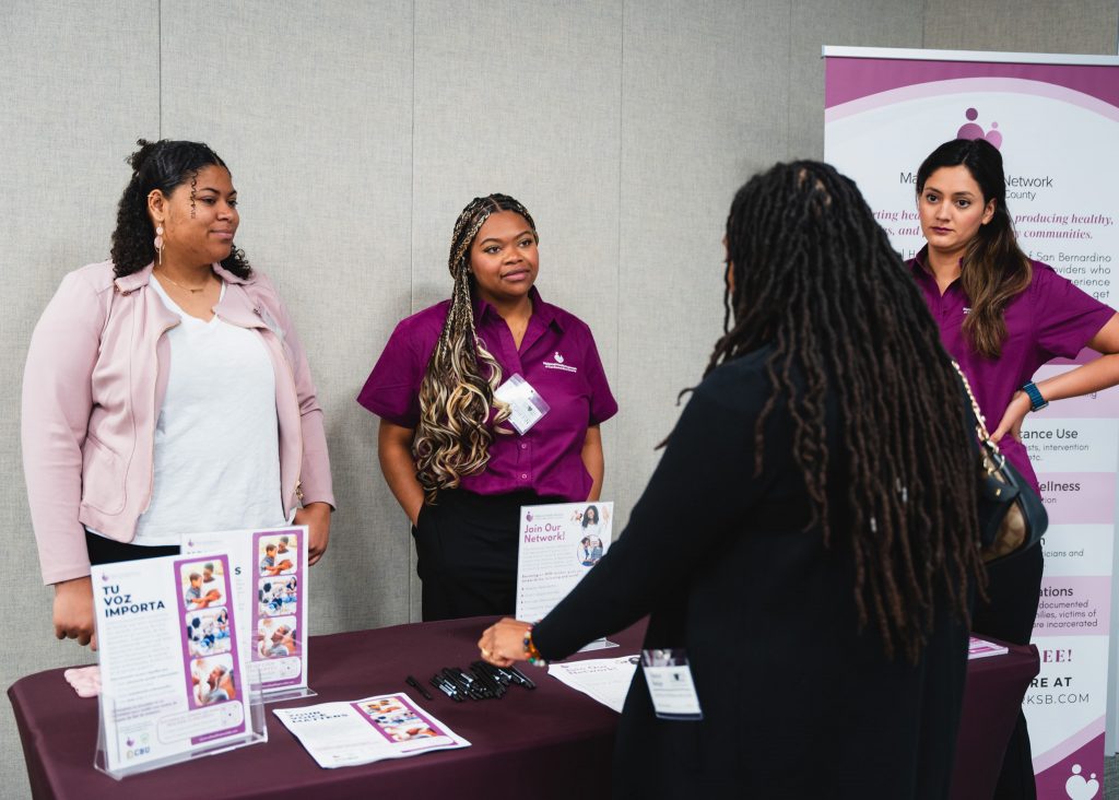 Four women at a demonstration stand at the 2024 Perinatal Equity Initiative (PEI) Provider and Community Summit