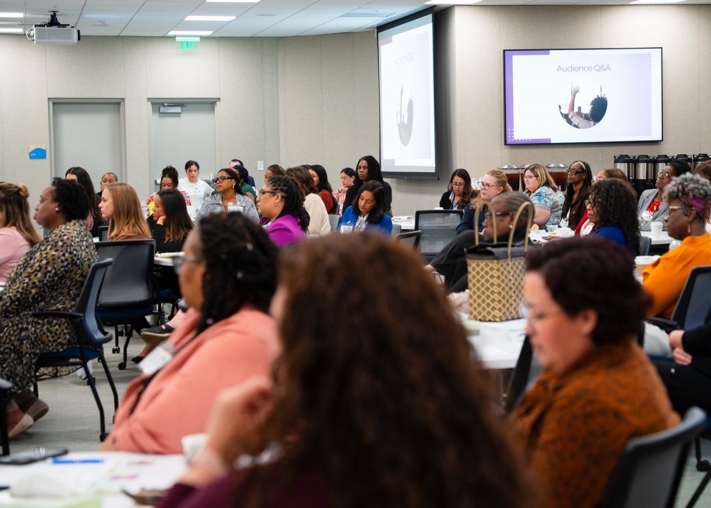 Attendants of the event looking on during a powerpoint presentation.